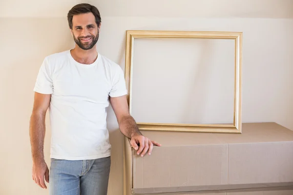 Hombre feliz con cajas móviles y marco — Foto de Stock