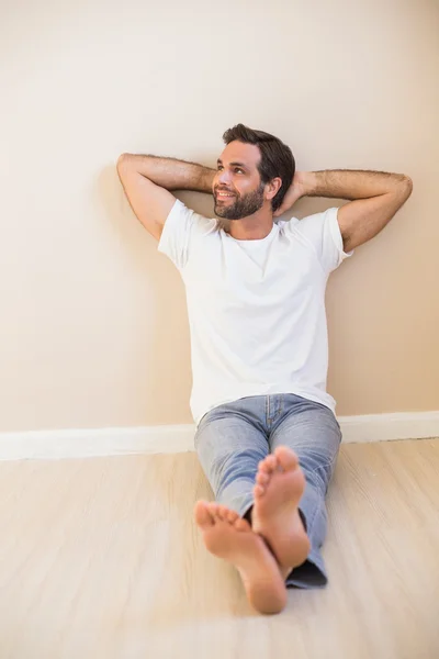 Glücklicher Mann auf dem Boden sitzend — Stockfoto