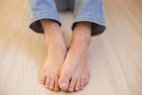 Mans bare feet on wooden floor — Stock Photo, Image