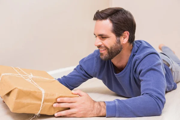 Homem feliz olhando para o pacote — Fotografia de Stock