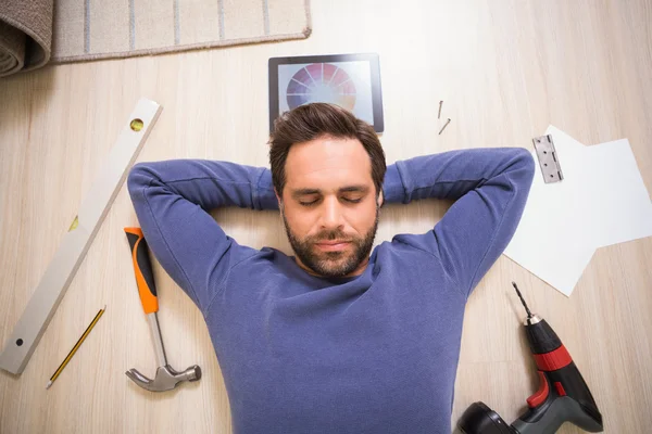 Casual adam DIY aletlerini tarafından çevrili katta yatan — Stok fotoğraf