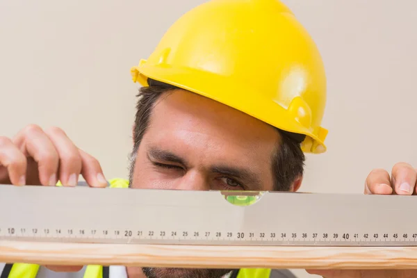 Pracownik budowlany wykorzystujący poziom alkoholu — Zdjęcie stockowe