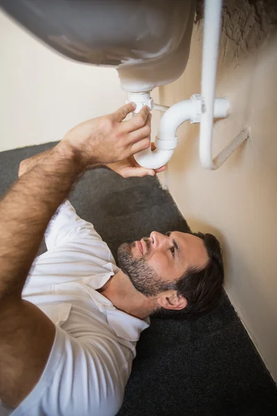 Fontanero fijando el fregadero en un baño — Foto de Stock