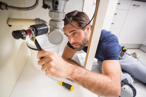 Plumber fixing under the sink — Stock Photo, Image