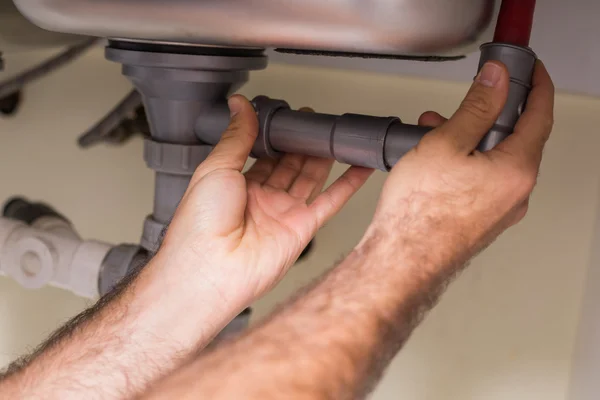 Plumber fixing under the sink — Stock Photo, Image