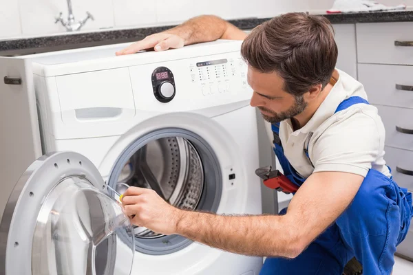 Handyman fixando uma máquina de lavar roupa — Fotografia de Stock