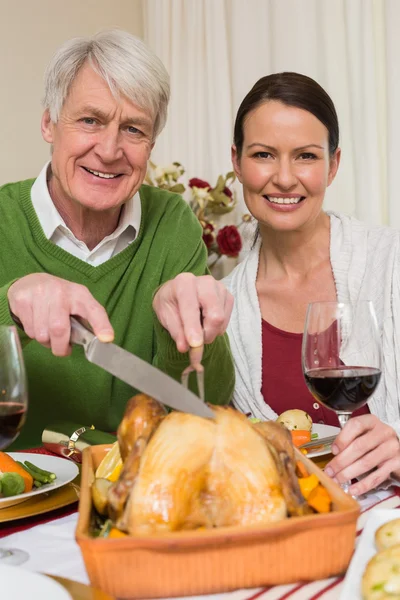 Grandfather carving chicken Stock Image