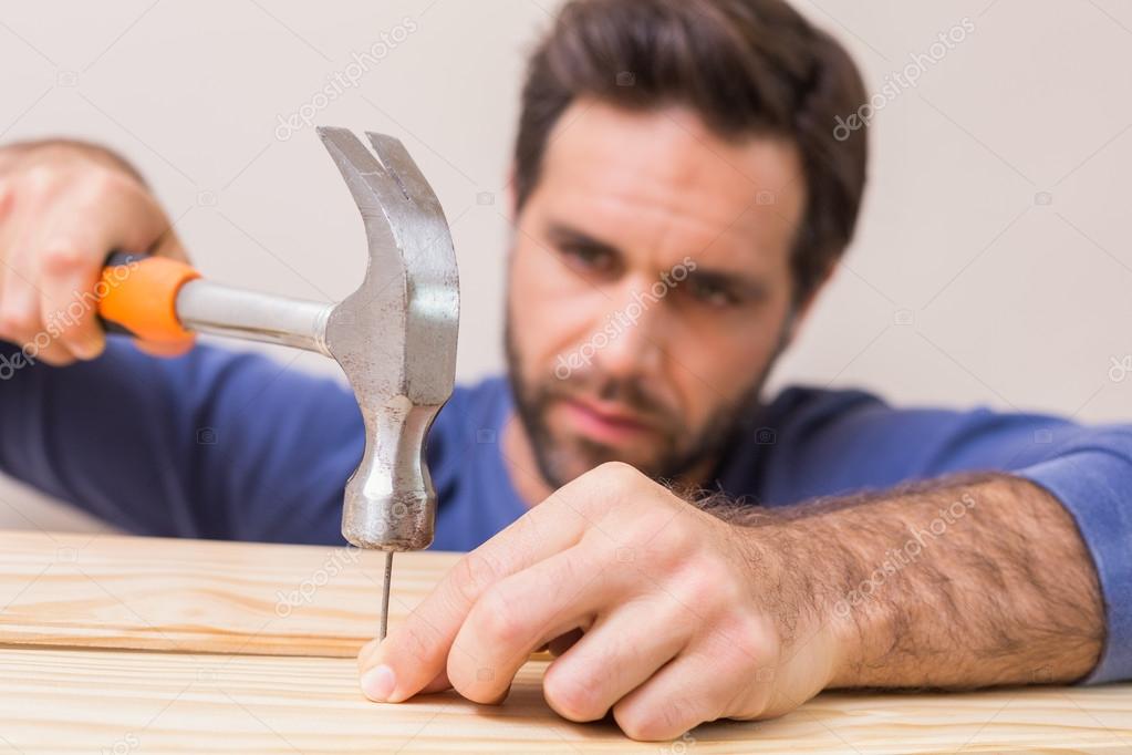 молоток для забивания гвоздей. молотком по полу. мужик с молотком. молоток для ламината фото. молоток на полу.
