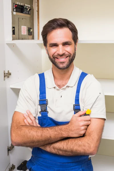 Handyman ler mot kameran — Stockfoto