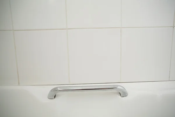 Metal handle in white bath — Stock Photo, Image