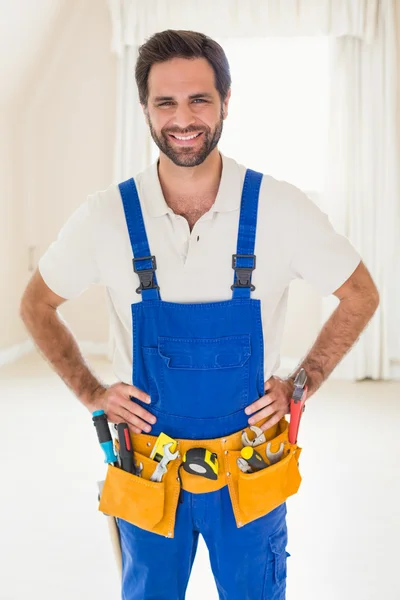 Heimwerker lächelt in Werkzeuggürtel in die Kamera — Stockfoto