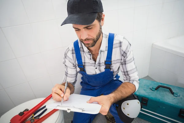 Klempner macht sich Notizen auf Klemmbrett — Stockfoto