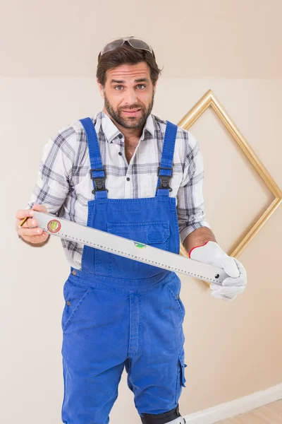 Trabalhador da construção confuso segurando nível de espírito — Fotografia de Stock