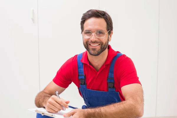 Bauarbeiter macht sich Notizen auf Klemmbrett — Stockfoto