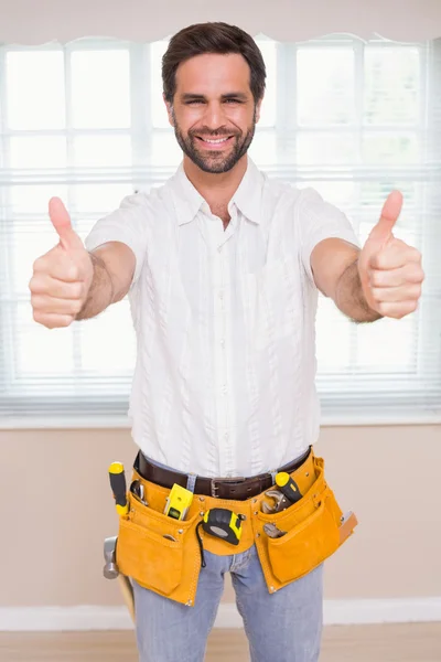 Handyman sorridente alla fotocamera nella cintura degli attrezzi — Foto Stock