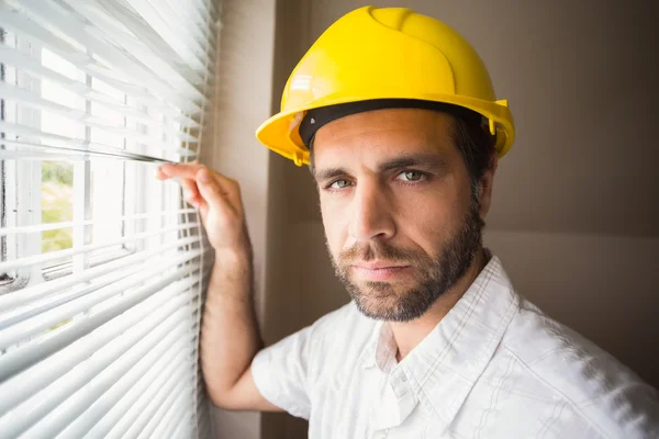 Handyman tittar ut genom fönstret — Stockfoto
