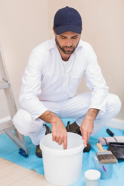 Pintor mezclando pintura en un cubo — Foto de Stock