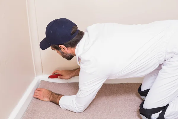 Handyman laying down a carpet — Stock Photo, Image