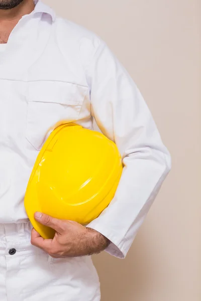 Handyman sosteniendo su casco amarillo — Foto de Stock