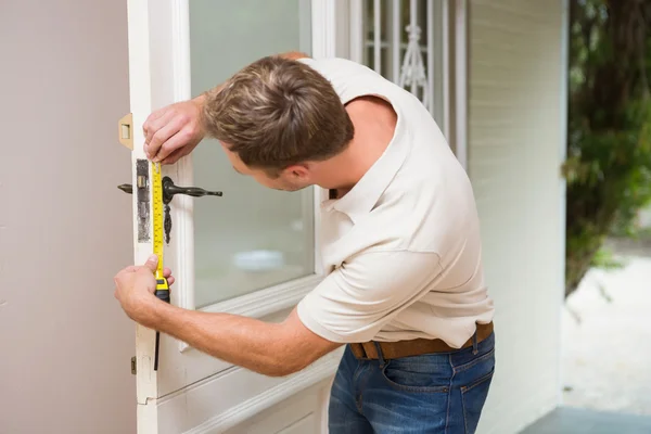 Construction worker using measuring tape — Stock Photo, Image