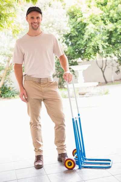 Gelukkig levering man leunend op trolley koffer — Stockfoto