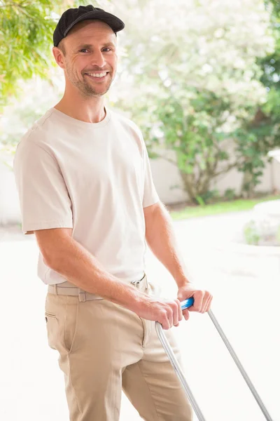Happy delivery man pushing trolley — Stock Photo, Image