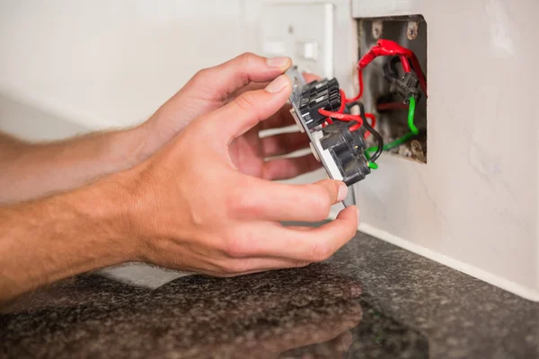 Manos comprobando las conexiones de cables eléctricos — Foto de Stock