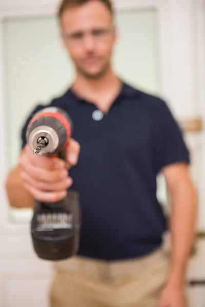 Handyman pointing power tool at camera — Stock Photo, Image