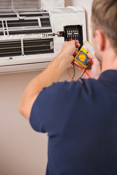 Focused handyman testing air conditioning — Stock Photo, Image