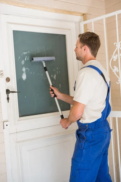 Handyman limpando a janela com rodos — Fotografia de Stock