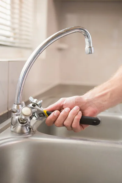 Man vaststelling kraan met een tang — Stockfoto