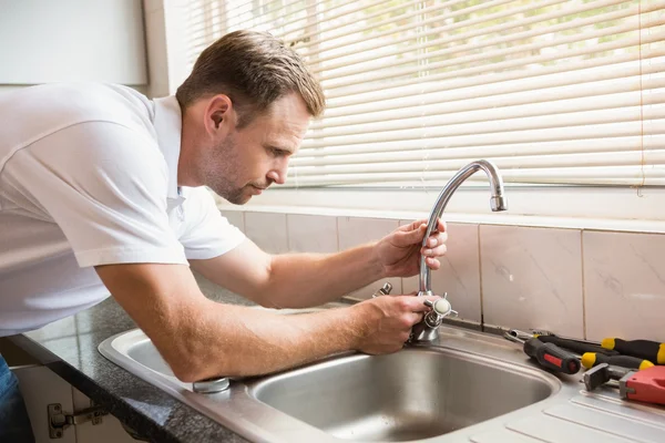 Mann fixiert Wasserhahn mit Zange — Stockfoto