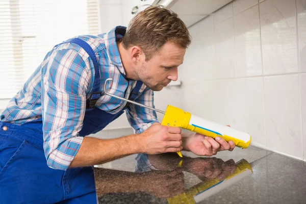 Fontanero poner relleno entre azulejos — Foto de Stock