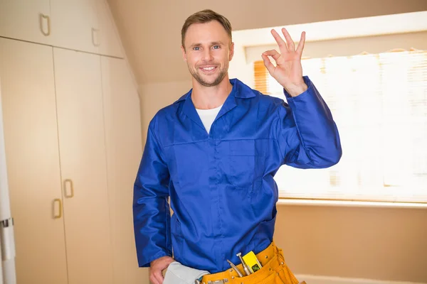 Handyman smiling at camera in tool belt — Stock Photo, Image