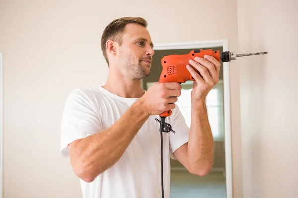 Construction worker drilling hole in wall — Stock Photo, Image