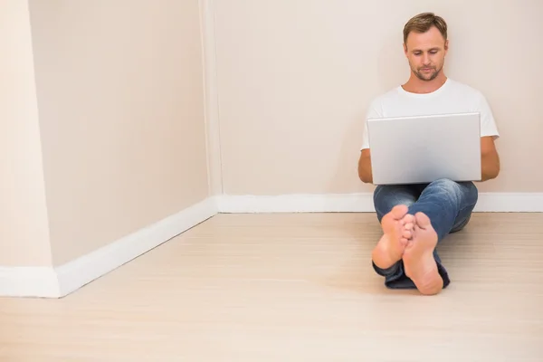 Fokuserade man använder laptop på golvet — Stockfoto