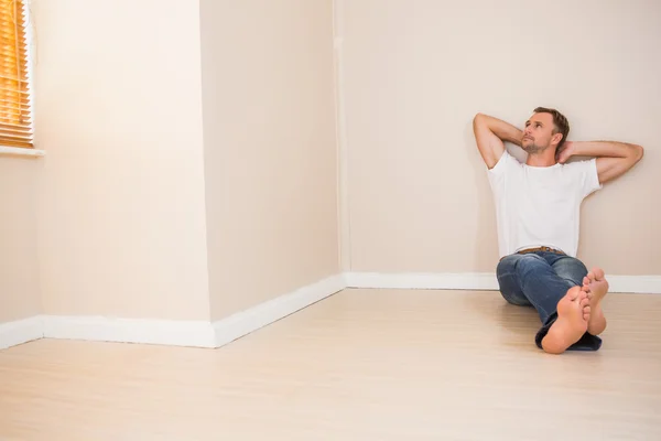 Glücklicher Mann auf dem Boden sitzend — Stockfoto