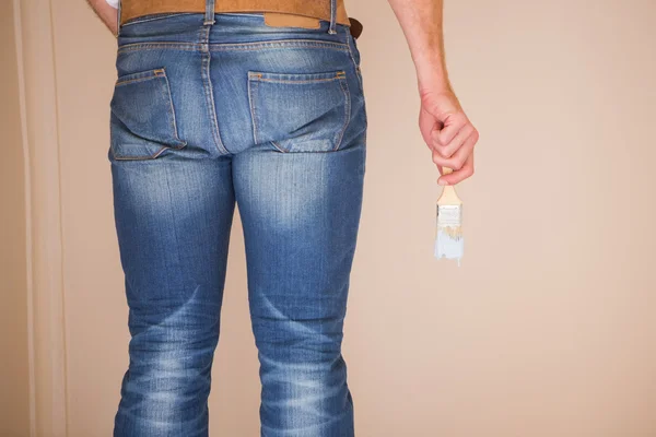 Rear view of painter holding a paintbrush — Stock Photo, Image