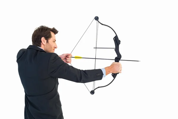 Businessman shooting bow and arrow — Stock Photo, Image