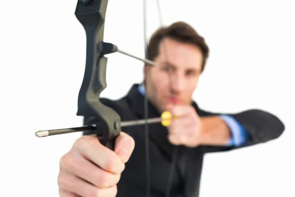 Businessman shooting bow and arrow — Stock Photo, Image