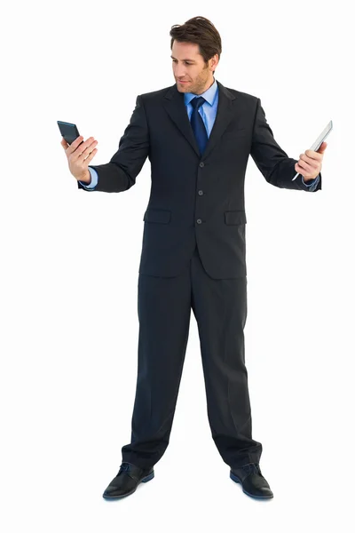 Бизнесмен смотрит на калькулятор и держит планшет — стоковое фото