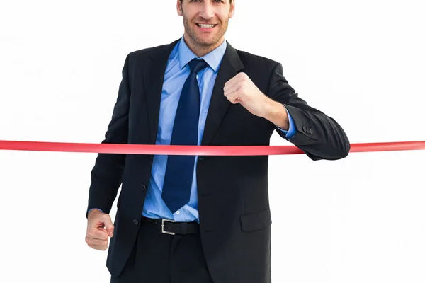 Happy businessman crossing finishing line — Stock Photo, Image