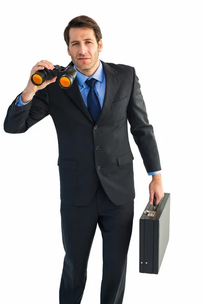 Un hombre de negocios serio sosteniendo prismáticos y un maletín — Foto de Stock