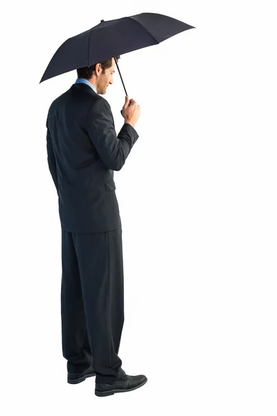 Rear view of classy businessman holding black umbrella — Stock Photo, Image