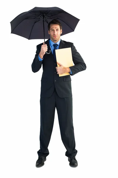 Empresário de pé sob guarda-chuva enquanto segurando pasta — Fotografia de Stock