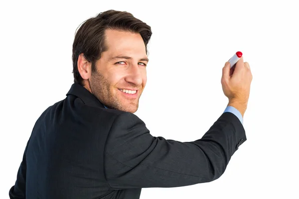 Businessman standing and writing while looking at camera — Stock Photo, Image