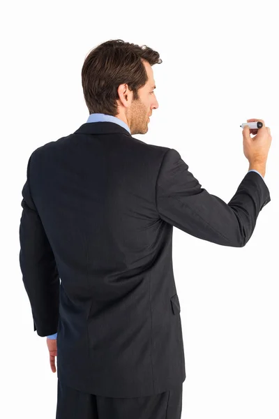 Бизнесмен, стоящий перед камерой и пишущий маркером — стоковое фото