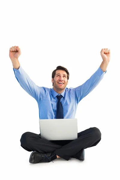 Businessman cheering with laptop sitting on floor — Stock Photo, Image