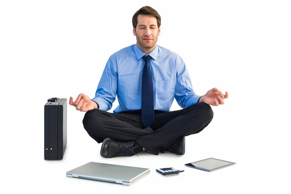 Man sitting in lotus pose with laptop, tablet and suitcase — Stock Photo, Image