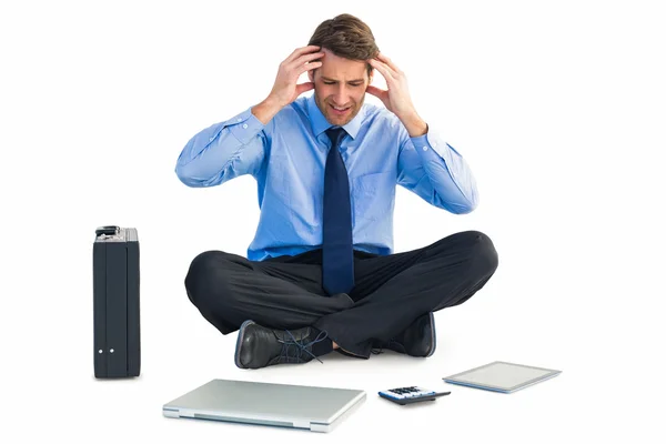 Businessman sitting on the floor with headache — Stock Photo, Image